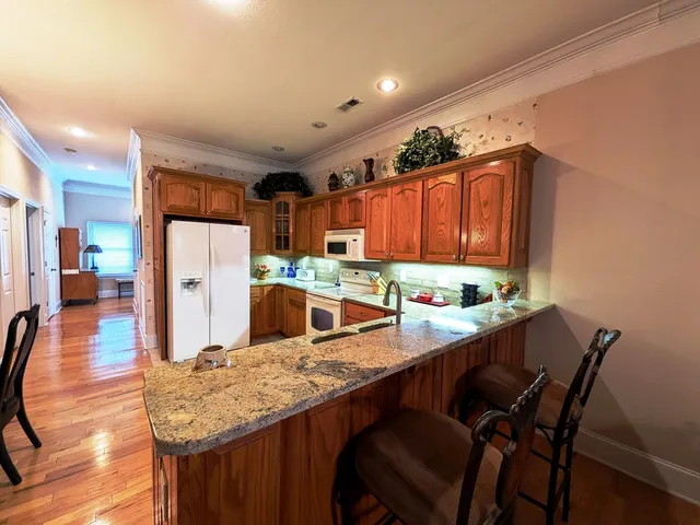 a kitchen with refrigerator and chairs