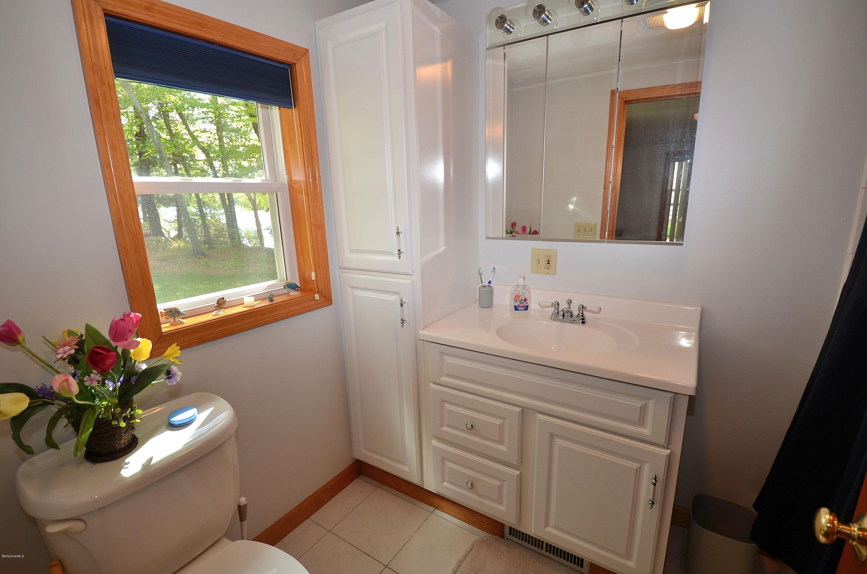 28 Ona Road Tolland, MA 01034 - Photo 11 of 31 a bathroom with a granite countertop sink a mirror and a shower