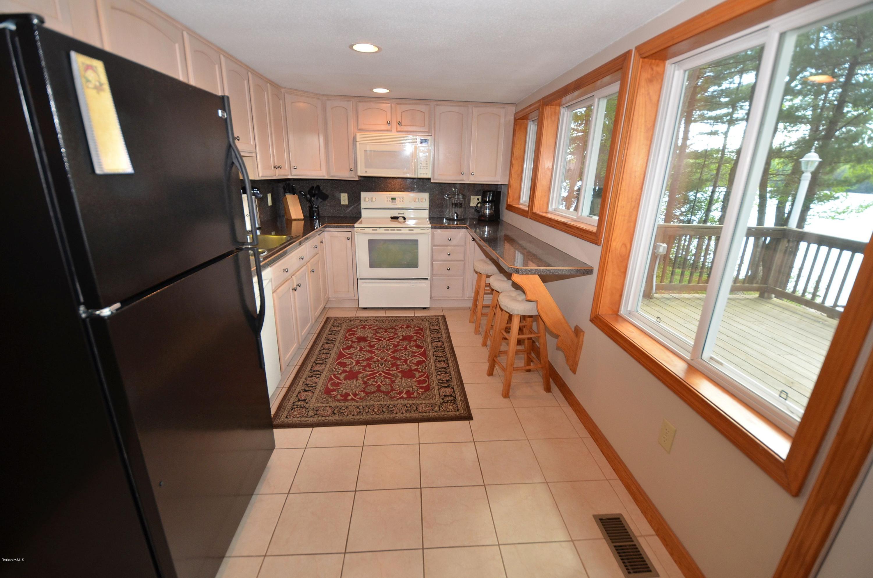 28 Ona Road Tolland, MA 01034 - Photo 5 of 31 a kitchen with stainless steel appliances granite countertop a refrigerator a stove a sink and a large window