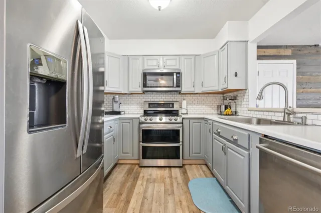 a kitchen with stainless steel appliances a stove sink and refrigerator