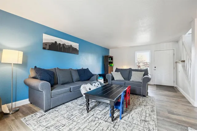 a living room with furniture wooden floor and a lamp