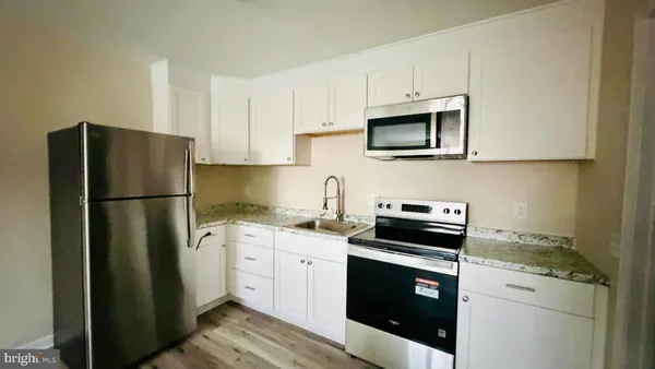 a kitchen with cabinets stainless steel appliances and a counter space