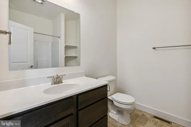 a bathroom with a sink a toilet a vanity and mirror
