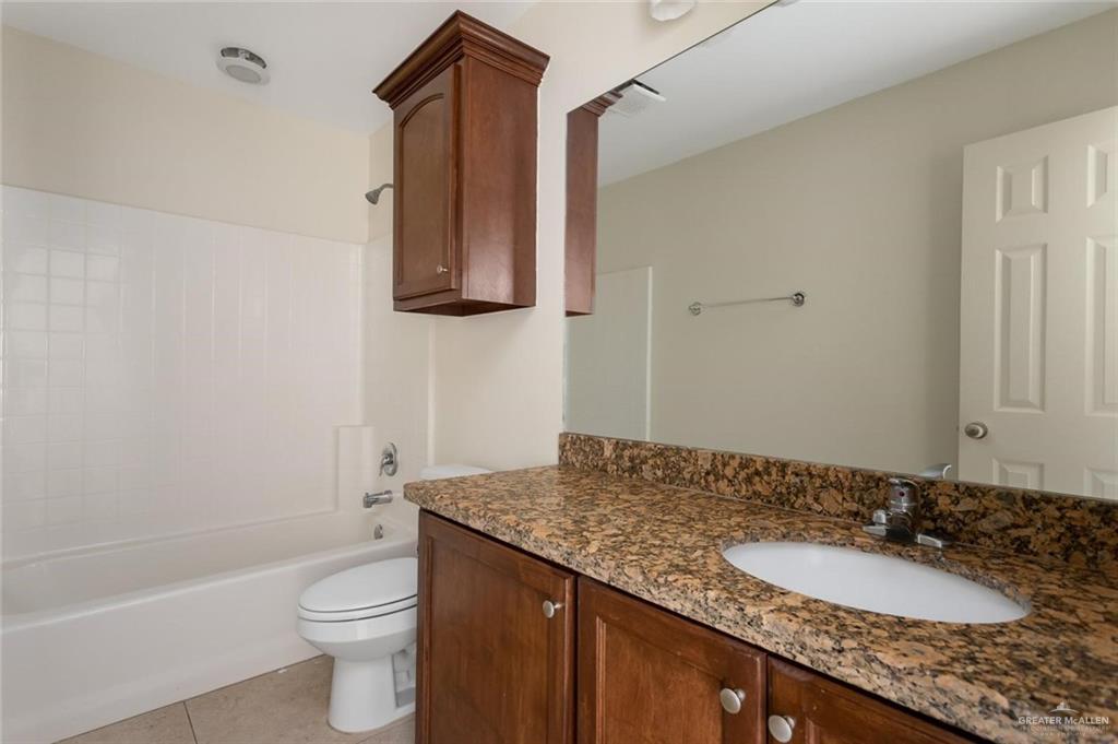 1105 West Stubbs Street, Unit 5 Edinburg, TX 78539 - Photo 12 of 12 a bathroom with a granite countertop sink toilet and shower