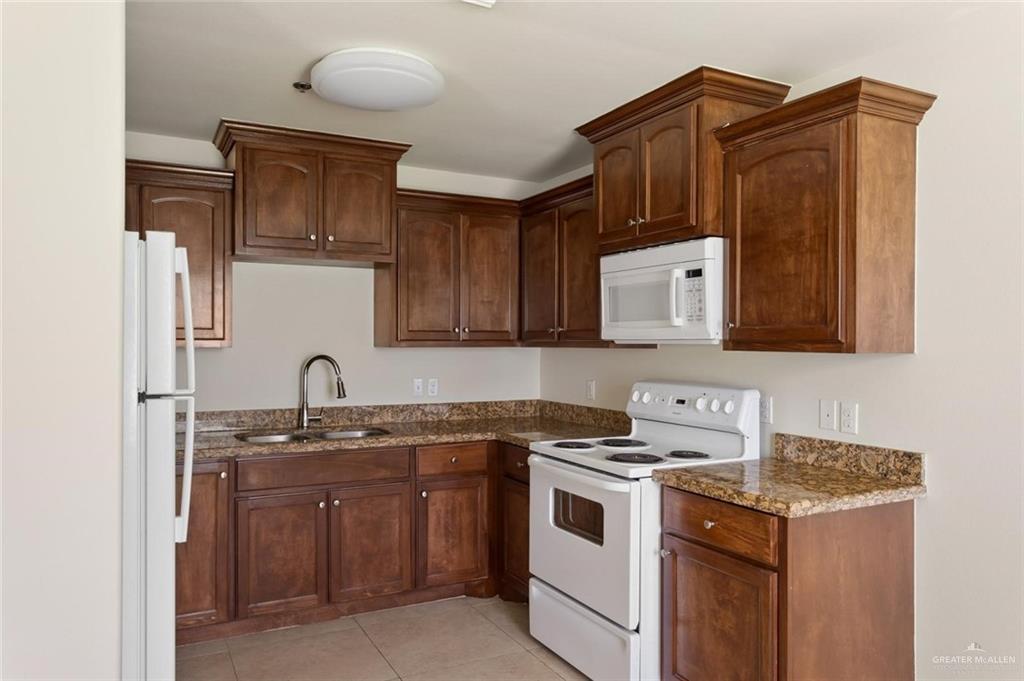 1105 West Stubbs Street, Unit 5 Edinburg, TX 78539 - Photo 5 of 12 a kitchen with stainless steel appliances granite countertop a sink stove and cabinets
