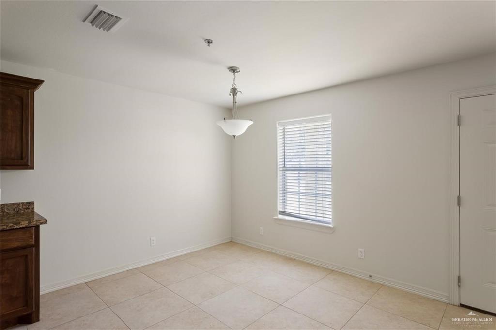 1105 West Stubbs Street, Unit 5 Edinburg, TX 78539 - Photo 10 of 12 an empty room with chandelier fan and windows