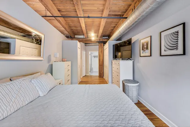 a bedroom with a large bed next to a window