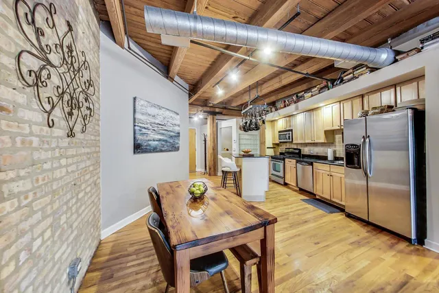 a kitchen with granite countertop a refrigerator and wooden floor