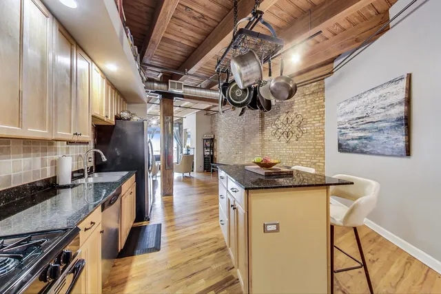 a kitchen with stainless steel appliances granite countertop a sink a stove and cabinets