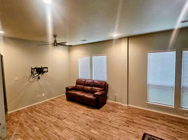 a living room with furniture and a wooden floor