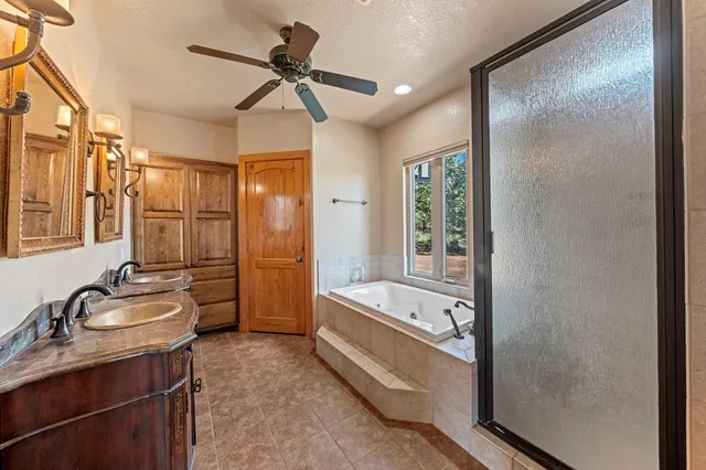a bathroom with a tub a sink a mirror and a shower