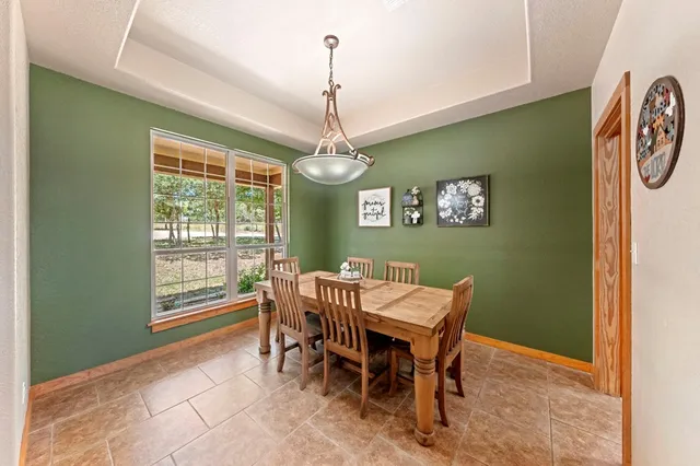 a dining room with a wooden table and chairs