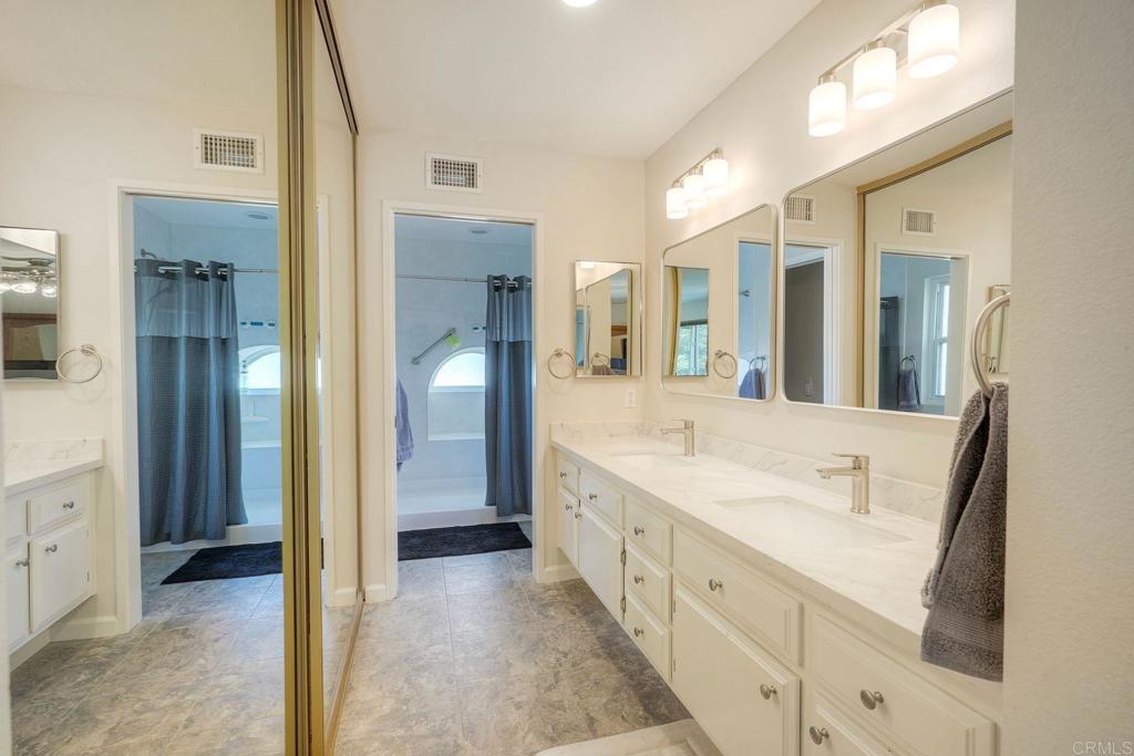 13639 Freeport Road San Diego, CA 92129 - Photo 22 of 44 a spacious bathroom with a shower sink and mirror