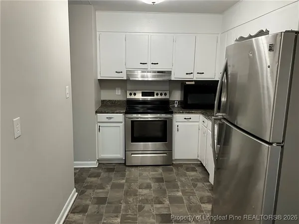 a kitchen with a stove a refrigerator and a sink