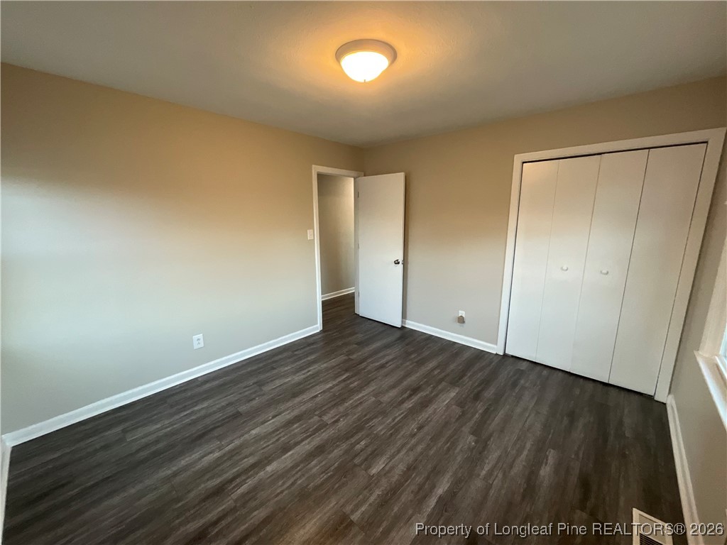 2238 Hope Mills Road Fayetteville, NC 28304 - Photo 8 of 9 an empty room with wooden floor and windows