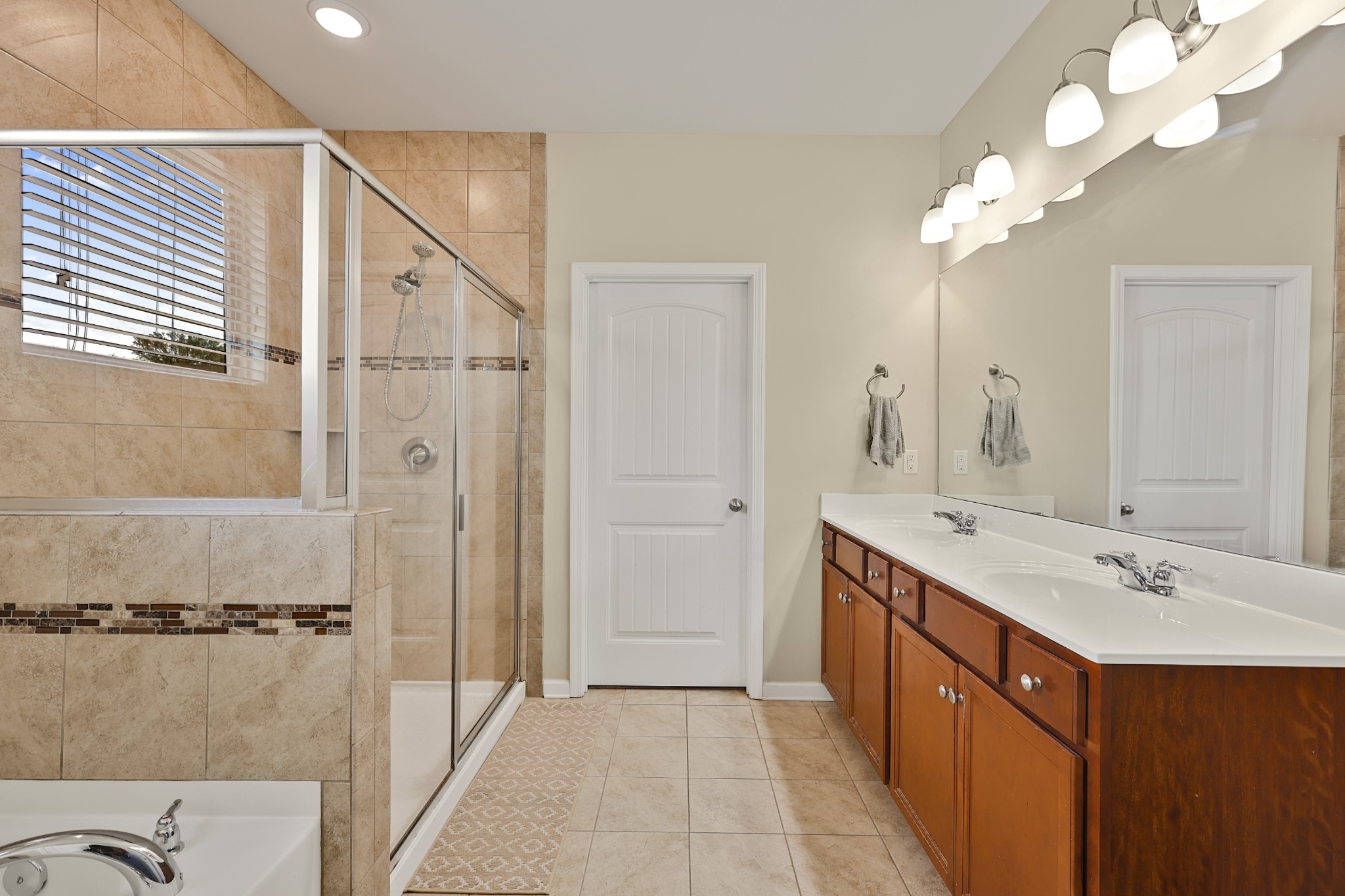 6515 Tulip Tree Drive Murfreesboro, TN 37128 - Photo 12 of 21 a bathroom with a double vanity sink a large mirror and shower