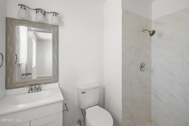 a bathroom with a toilet sink vanity and mirror
