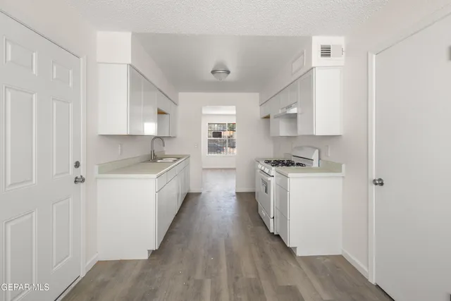 a kitchen with sink cabinets and white appliances