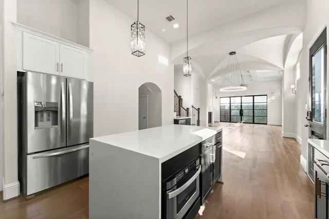 a large kitchen with stainless steel appliances a refrigerator a sink and a stove