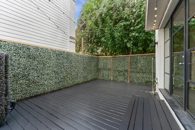 a view of a balcony with wooden floor and fence