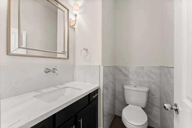 a bathroom with a sink a toilet and mirror