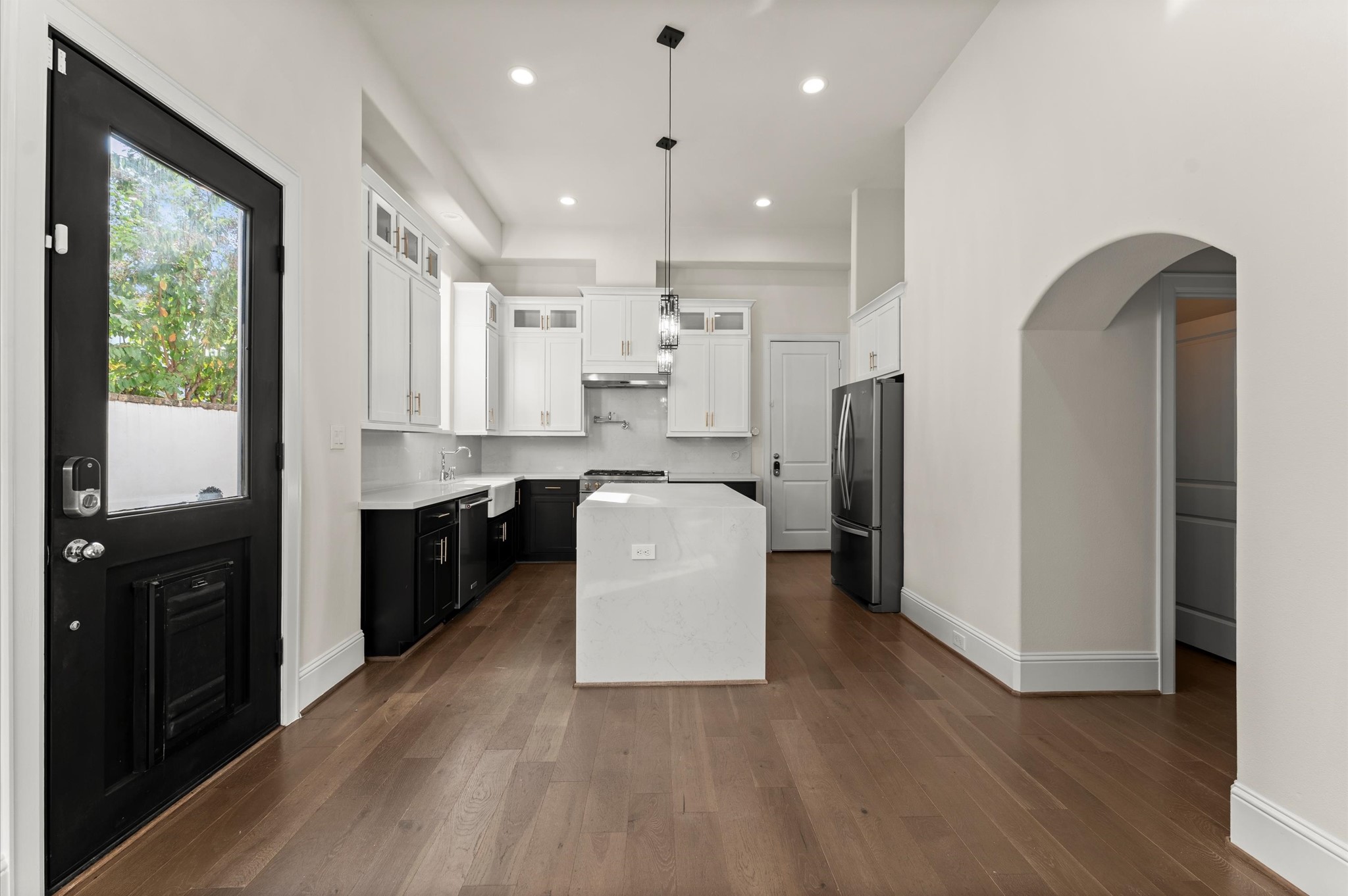 1902 West 25th Street Houston, TX 77008 - Photo 20 of 49 a kitchen with kitchen island wooden floors appliances and cabinets