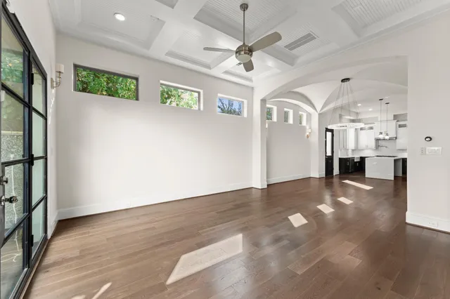 a view of a hallway with wooden floor and a kitchen