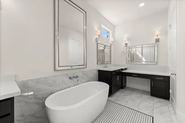 a bathroom with a bathtub a sink a mirror and a shower