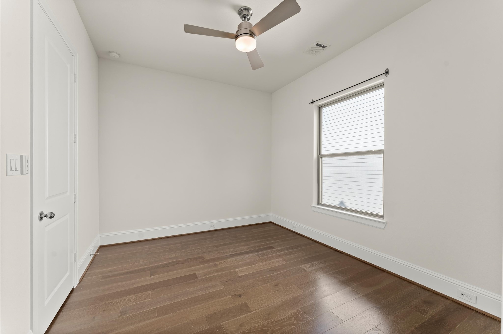 1902 West 25th Street Houston, TX 77008 - Photo 33 of 49 an empty room with wooden floor ceiling fan and windows