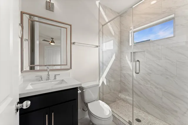 a bathroom with a sink a toilet and shower