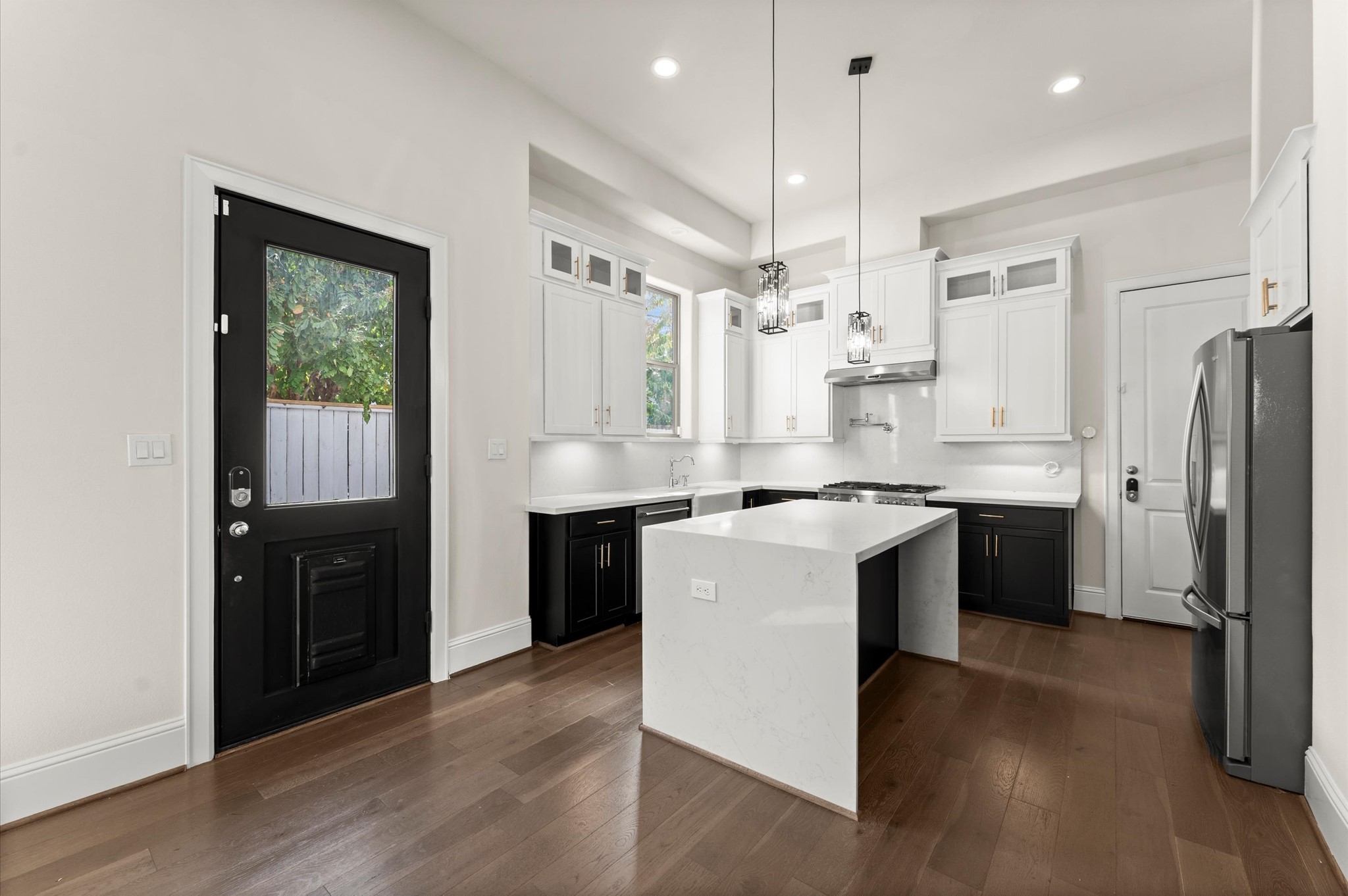 1902 West 25th Street Houston, TX 77008 - Photo 9 of 49 a kitchen with kitchen island granite countertop a refrigerator a sink dishwasher a stove and white cabinets with wooden floor