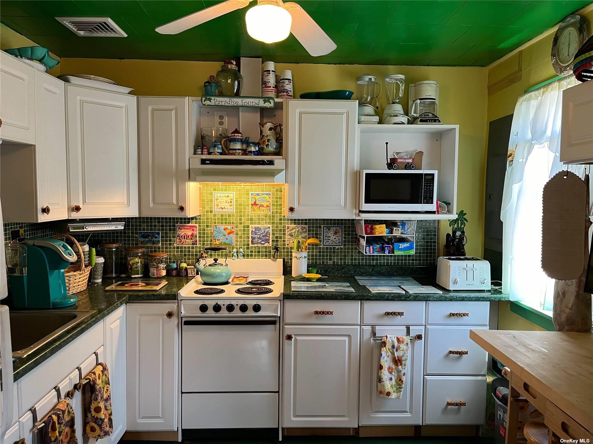 4 Surf View Walk Ocean Beach, NY 11770 - Photo 2 of 15 a kitchen with stainless steel appliances a stove a sink and a microwave