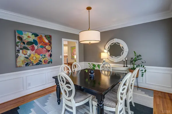 a kitchen with stainless steel appliances granite countertop a refrigerator a sink dishwasher a stove and a dining table with wooden floor