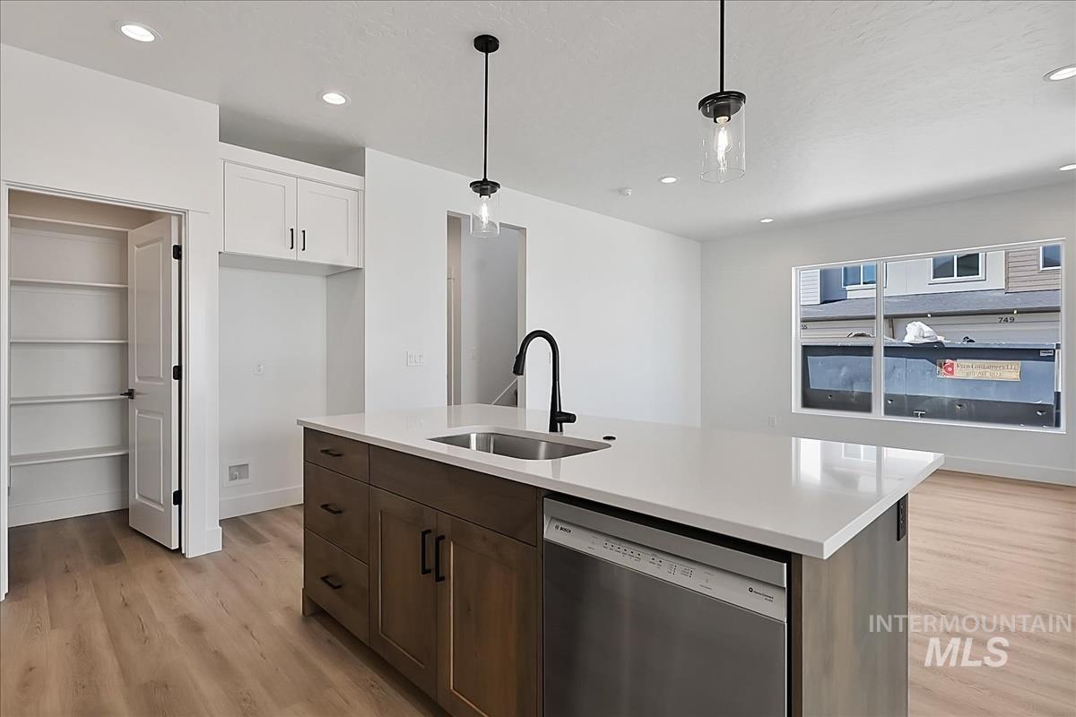 776 South Calhoun Lane Star, ID 83669 - Photo 11 of 49 Modern kitchen island with a built-in stainless steel dishwasher, undermount sink with matte black faucet, and light-toned countertop