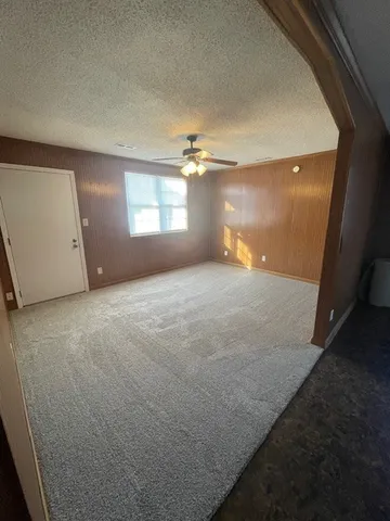 en empty room with windows and a ceiling fan