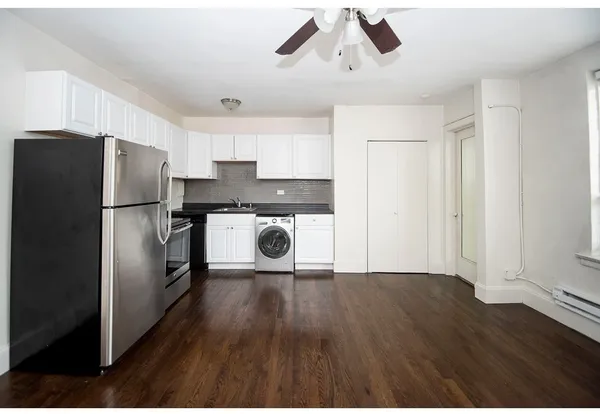 a kitchen with a refrigerator sink and cabinets