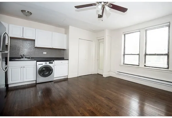 a view of a kitchen with wooden floor and stainless steel appliances