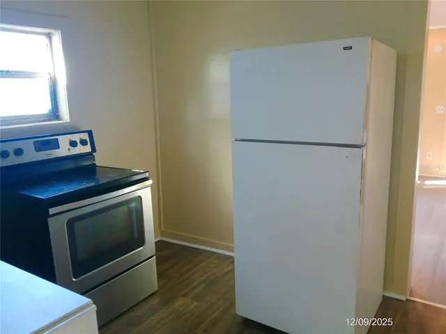 a white refrigerator freezer and a stove sitting inside of a kitchen