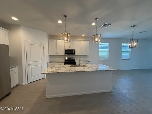 a large kitchen with granite countertop a large kitchen island and a sink