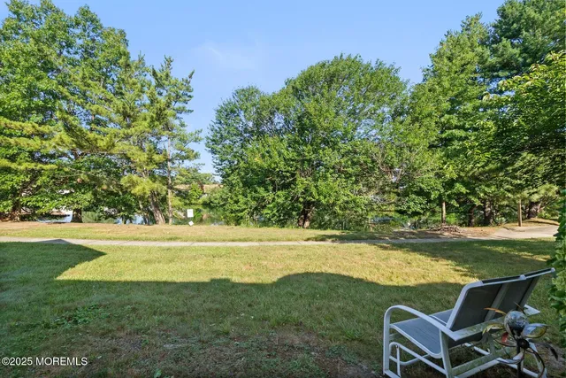 a view of a house with backyard and trees