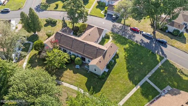 an aerial view of residential houses with outdoor space and trees