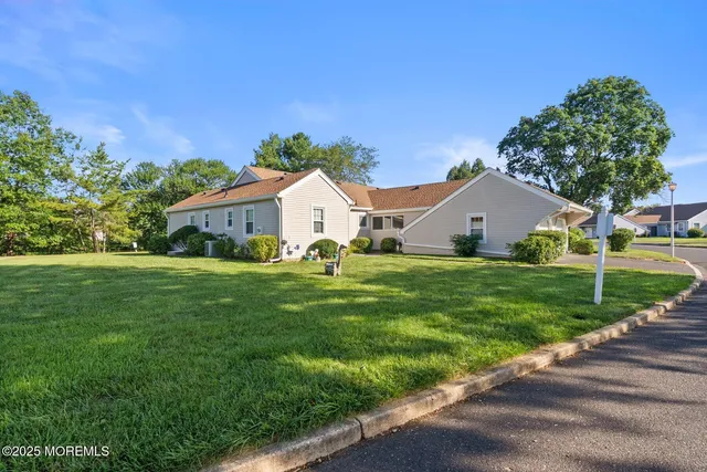 a view of house with garden and tall trees