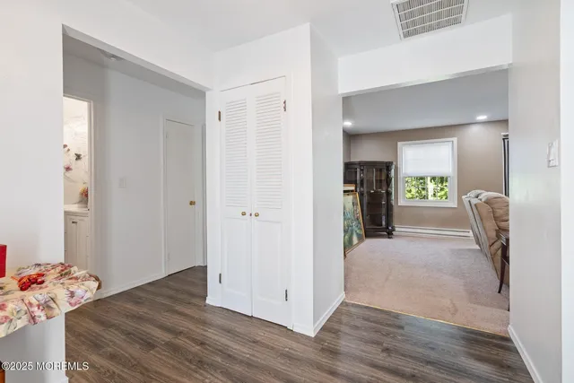 a view of a hallway with wooden floor and a refrigerator