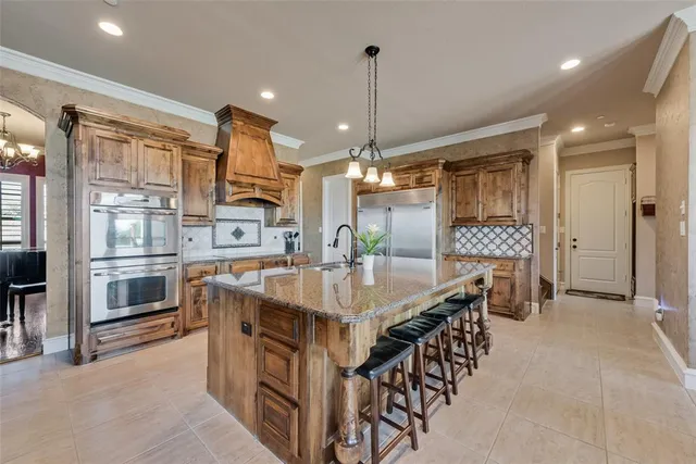 a kitchen with stainless steel appliances granite countertop a kitchen island a stove and a sink