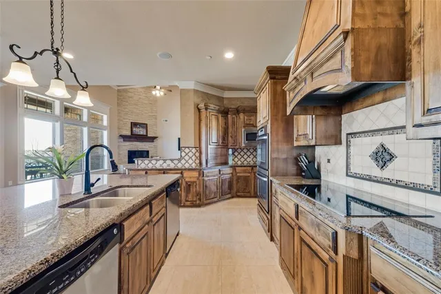 a kitchen with granite countertop a sink a counter top space appliances and cabinets