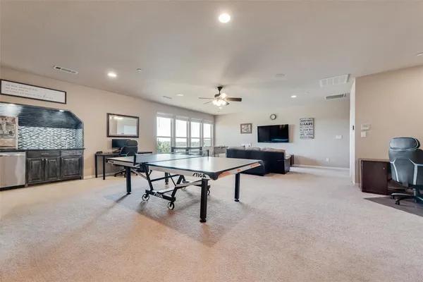 a view of a workspace with furniture and a ceiling fan