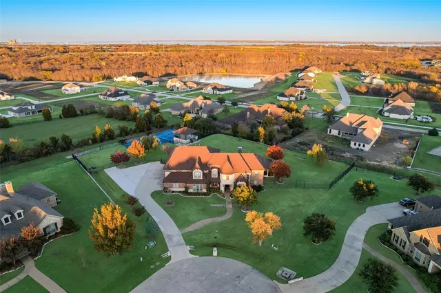 an aerial view of residential houses with outdoor space and trees
