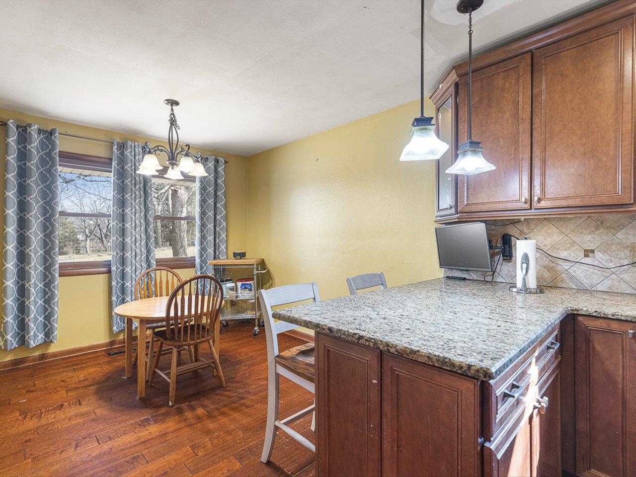 10383 Atwood Road Roscoe, IL 61073 - Photo 12 of 42 a kitchen with a table chairs and wooden floor