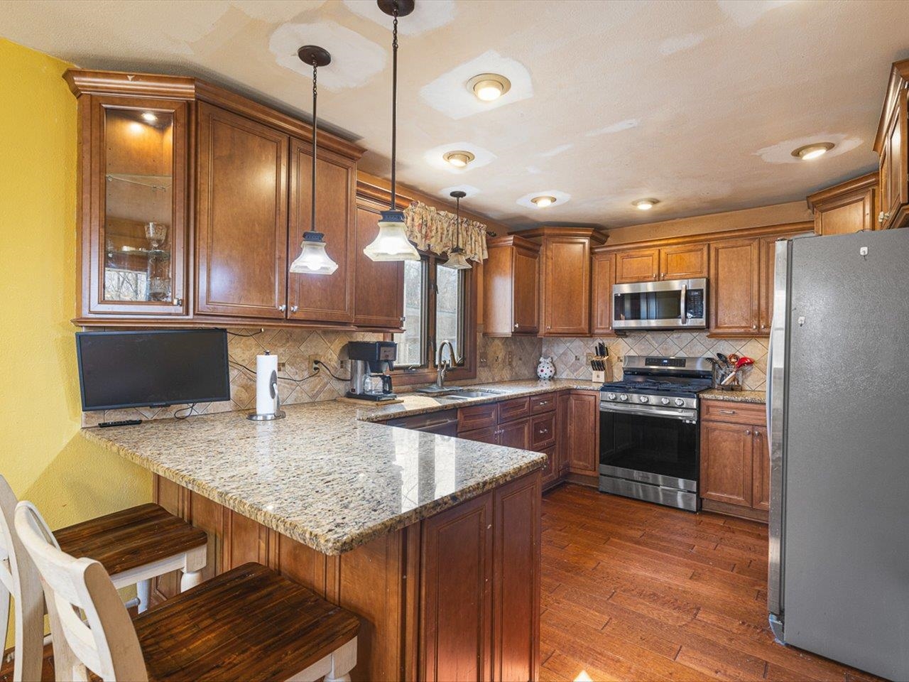 10383 Atwood Road Roscoe, IL 61073 - Photo 14 of 42 a kitchen with granite countertop stainless steel appliances and wooden cabinets