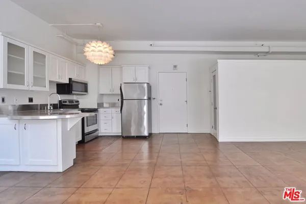 a kitchen with a refrigerator a microwave and cabinets